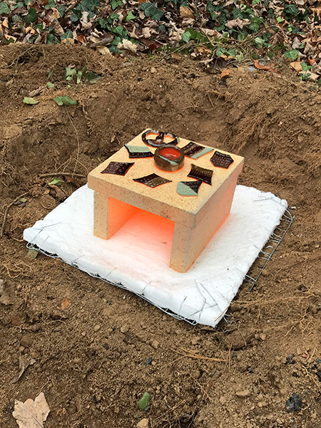 kiln top removed showing red hot pieces